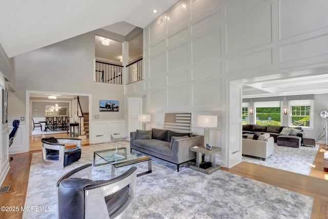 12 Wagon Way, Holmdel, NJ 07733 - living area featuring a decorative wall, a high ceiling, wood finished floors, and a chandelier
