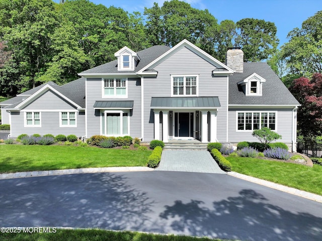 12 Wagon Way, Holmdel, NJ 07733 - view of front facade featuring a front lawn, a standing seam roof, a shingled roof, a chimney, and metal roof