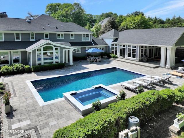 12 Wagon Way, Holmdel, NJ 07733 - view of swimming pool featuring a patio area, an exterior structure, a pool with connected hot tub, outdoor dining area, and an outbuilding