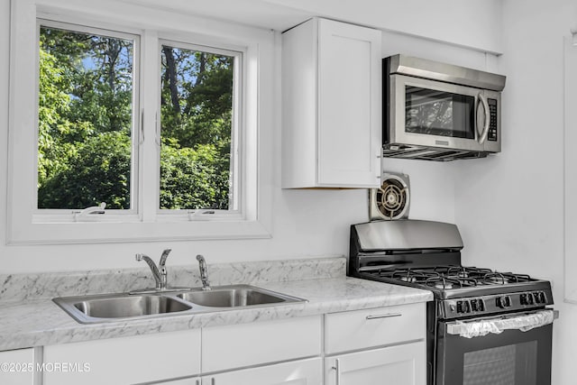 1324 Sixth Ave, Toms River, NJ 08757 - kitchen featuring stainless steel microwave, gas stove, a sink, light countertops, and white cabinetry