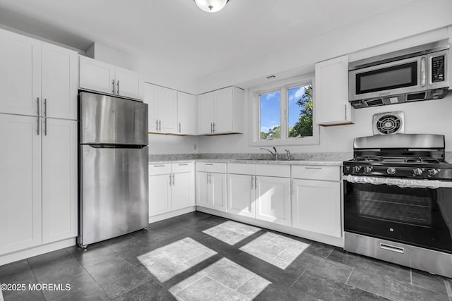 1324 Sixth Ave, Toms River, NJ 08757 - kitchen featuring stainless steel appliances, a sink, white cabinetry, and light stone countertops
