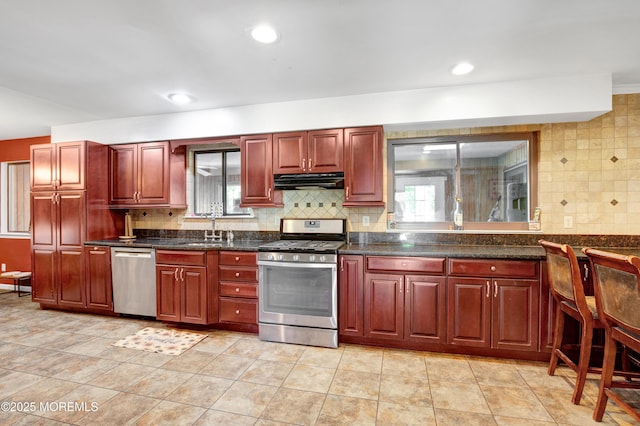 16 Markwood Dr, Howell, NJ 07731 - kitchen with stainless steel appliances, reddish brown cabinets, under cabinet range hood, a sink, and recessed lighting