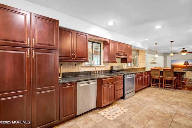 16 Markwood Dr, Howell, NJ 07731 - kitchen featuring appliances with stainless steel finishes, under cabinet range hood, a sink, hanging light fixtures, and a peninsula