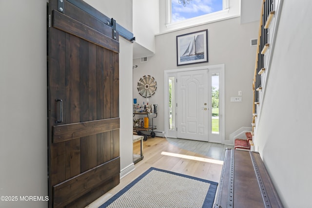 274 Beachview Ave, Manahawkin, NJ 08050 - entrance foyer with healthy amount of natural light, stairway, a towering ceiling, light wood-style floors, and baseboards