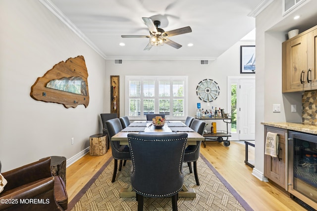 274 Beachview Ave, Manahawkin, NJ 08050 - dining area with beverage cooler, a ceiling fan, a bar, crown molding, and light wood-style floors