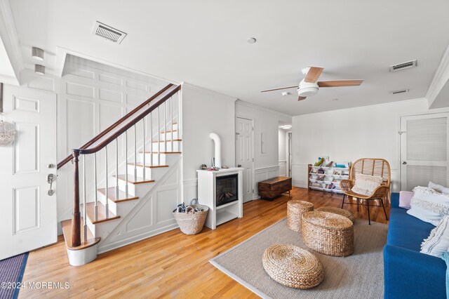 16 Beach Blvd Unit 2, Highlands, NJ 07732 - living area with a decorative wall, crown molding, light wood-style floors, ceiling fan, and stairs