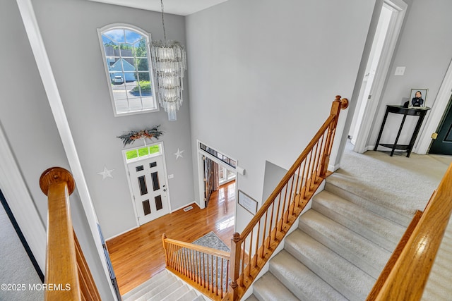 707 Cedar Point Ct, Toms River, NJ 08753 - stairway with a chandelier, wood finished floors, a towering ceiling, and baseboards