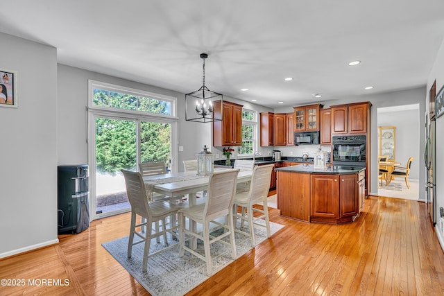 707 Cedar Point Ct, Toms River, NJ 08753 - kitchen with black appliances, a center island, light wood-type flooring, a chandelier, and brown cabinetry