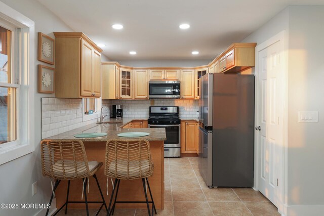 151 Shore Dr, Brick, NJ 08723 - kitchen with appliances with stainless steel finishes, a sink, a peninsula, light brown cabinets, and tasteful backsplash
