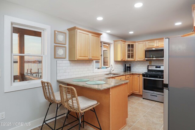 151 Shore Dr, Brick, NJ 08723 - kitchen featuring stainless steel appliances, light brown cabinetry, a sink, a peninsula, and tasteful backsplash
