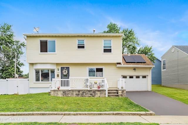 39 Scholer Dr, Union Beach, NJ 07735 - colonial house featuring covered porch, a garage, roof mounted solar panels, driveway, and a gate