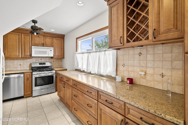 39 Scholer Dr, Union Beach, NJ 07735 - kitchen featuring appliances with stainless steel finishes, brown cabinetry, decorative backsplash, light tile patterned flooring, and recessed lighting