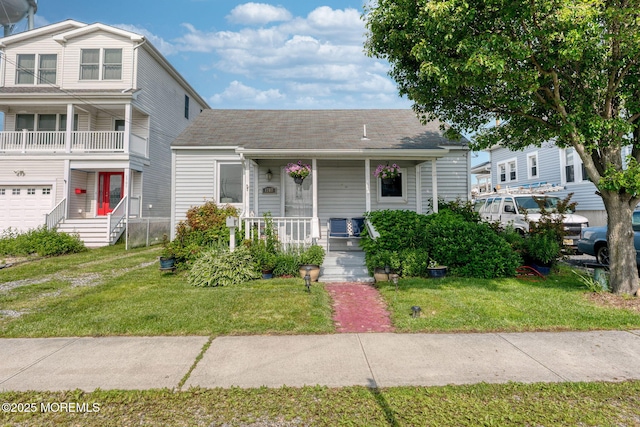 1707-1705 N Bayview Ave, Seaside Park, NJ 08752 - view of front of house featuring a porch, a front lawn, and roof with shingles