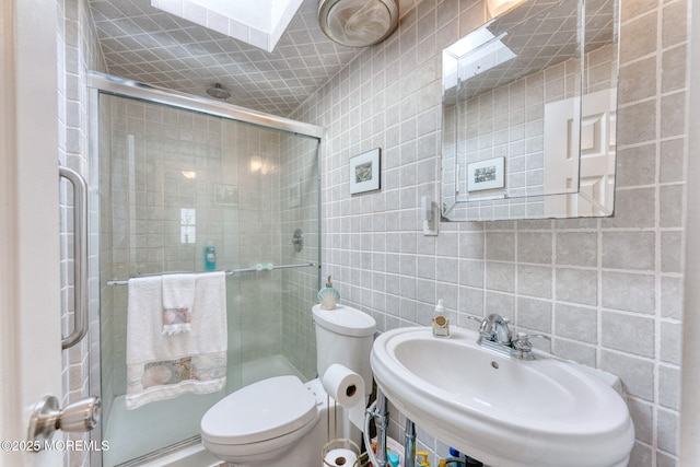 1707-1705 N Bayview Ave, Seaside Park, NJ 08752 - bathroom featuring tile walls, a sink, toilet, a stall shower, and tasteful backsplash