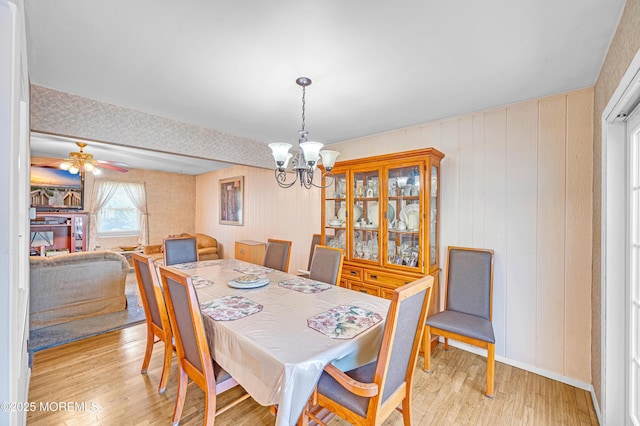 14 N Longview Rd, Howell, NJ 07731 - dining area with a chandelier, light wood-style floors, wood walls, ceiling fan, and baseboards