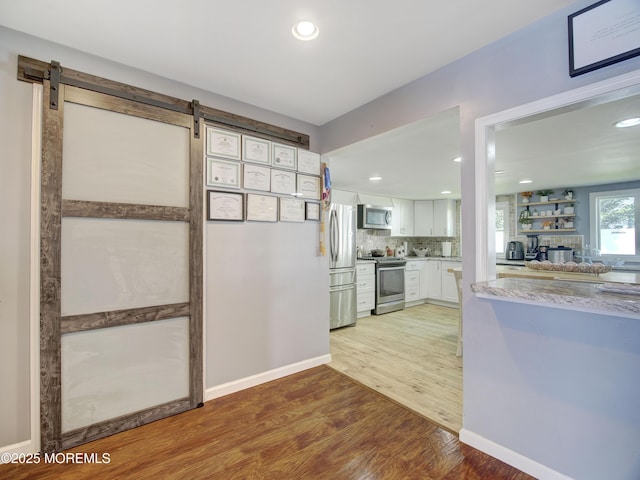 30 Mountain Ave, Hazlet, NJ 07730 - kitchen featuring stainless steel appliances, white cabinetry, light wood finished floors, light countertops, and a barn door