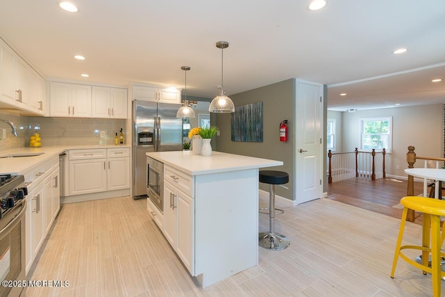 21 Wickatunk Rd, Manalapan, NJ 07726 - kitchen featuring appliances with stainless steel finishes, a sink, a breakfast bar area, a kitchen island, and recessed lighting