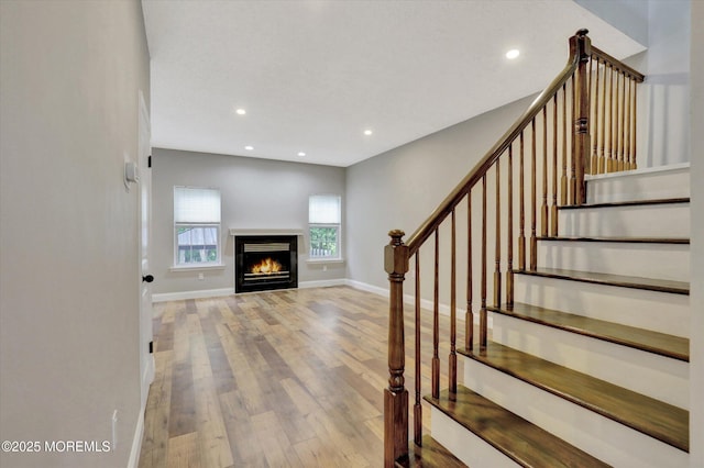 1103 Creamery Ct, Freehold, NJ 07728 - stairs featuring wood finished floors, recessed lighting, and a warm lit fireplace