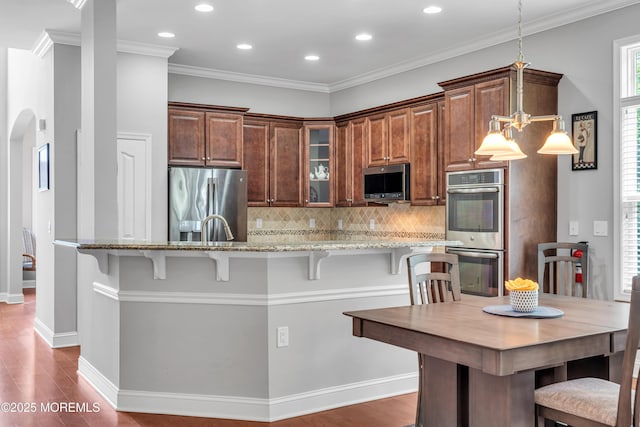 24 Beach Haven Way, Waretown, NJ 08758 - kitchen featuring stainless steel appliances, light stone counters, recessed lighting, a kitchen bar, and dark wood-style flooring