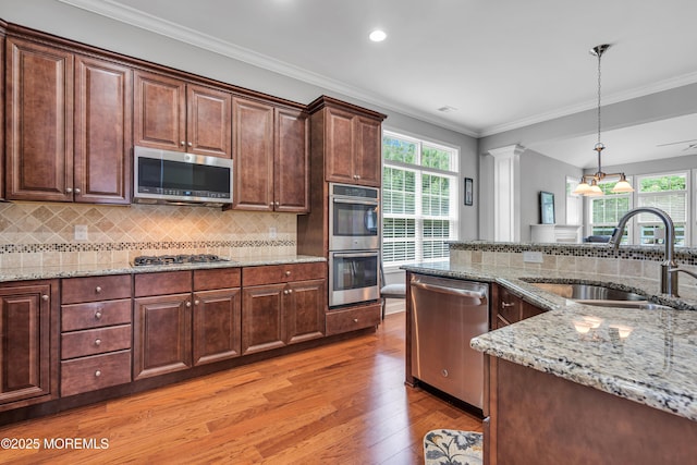 24 Beach Haven Way, Waretown, NJ 08758 - kitchen featuring appliances with stainless steel finishes, a sink, light wood-type flooring, healthy amount of natural light, and ornamental molding