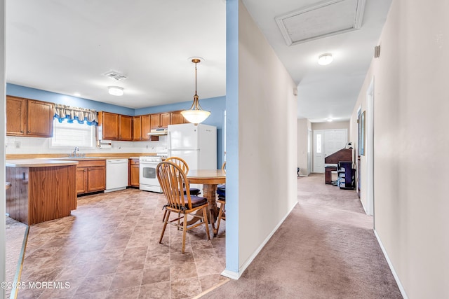 184 Pulaski Blvd, Toms River, NJ 08757 - kitchen with white appliances, under cabinet range hood, a sink, light countertops, and brown cabinetry