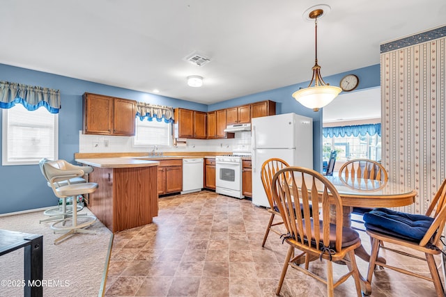 184 Pulaski Blvd, Toms River, NJ 08757 - kitchen featuring white appliances, under cabinet range hood, light countertops, a sink, and brown cabinets