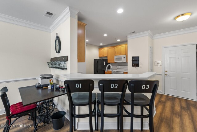 100 Middlesex Blvd Unit 144, Plainsboro, NJ 08536 - kitchen featuring white appliances, ornamental molding, dark wood finished floors, a breakfast bar, and a peninsula