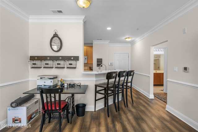 100 Middlesex Blvd Unit 144, Plainsboro, NJ 08536 - kitchen with crown molding, dark wood-type flooring, a breakfast bar area, a sink, and baseboards
