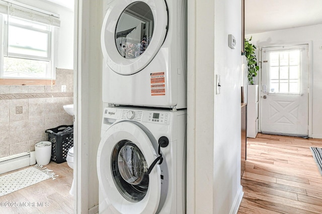 33 Cumberland Dr, Brick, NJ 08723 - laundry area with stacked washer and clothes dryer, tile walls, plenty of natural light, wood finished floors, and baseboard heating