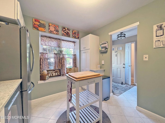 69 Bradford Ct, Aberdeen, NJ 07747 - kitchen with freestanding refrigerator, light tile patterned floors, light countertops, and white cabinetry