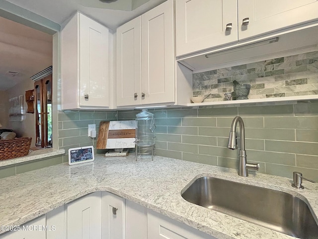 69 Bradford Ct, Aberdeen, NJ 07747 - kitchen with a sink, white cabinets, decorative backsplash, and light stone counters
