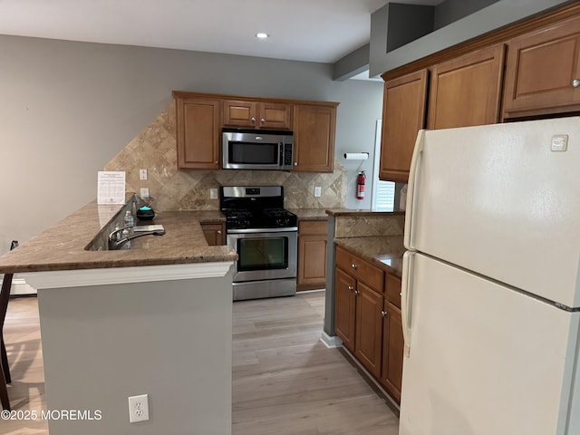300 Lareine Ave, Bradley Beach, NJ 07720 - kitchen featuring appliances with stainless steel finishes, a peninsula, tasteful backsplash, light wood-style flooring, and recessed lighting