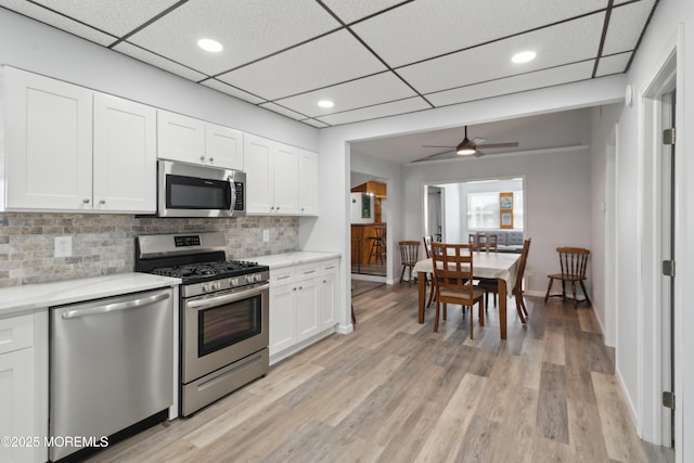 131 S Commodore Dr, Little Egg Harbor, NJ 08087 - kitchen with stainless steel appliances, backsplash, white cabinets, light wood-style flooring, and a ceiling fan