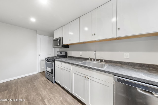 317 Bath Ave Unit 2, Long Branch, NJ 07740 - kitchen with stainless steel appliances, a sink, dark countertops, white cabinetry, and light wood-type flooring