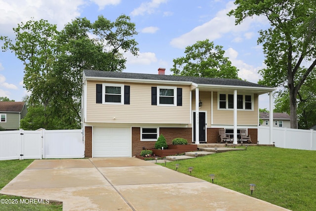 1117 Ruby Dr, Toms River, NJ 08753 - raised ranch featuring a gate, an attached garage, brick siding, a chimney, and concrete driveway