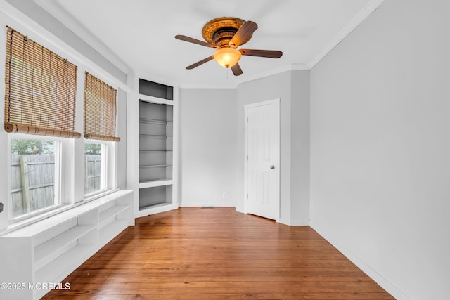 208 Cedar St, Lakehurst, NJ 08733 - empty room featuring built in shelves, hardwood / wood-style flooring, a ceiling fan, and ornamental molding
