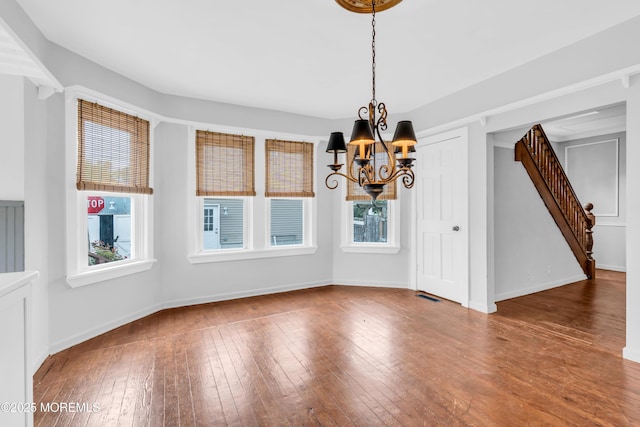 208 Cedar St, Lakehurst, NJ 08733 - unfurnished dining area featuring stairway, a chandelier, plenty of natural light, and hardwood / wood-style floors