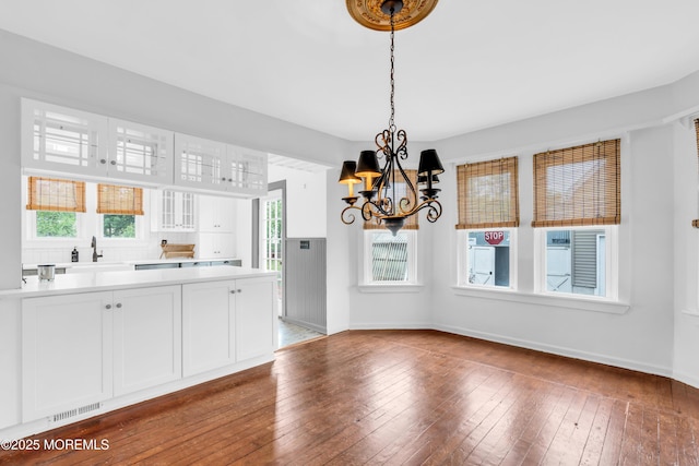 208 Cedar St, Lakehurst, NJ 08733 - kitchen featuring a sink, a chandelier, glass insert cabinets, and white cabinets