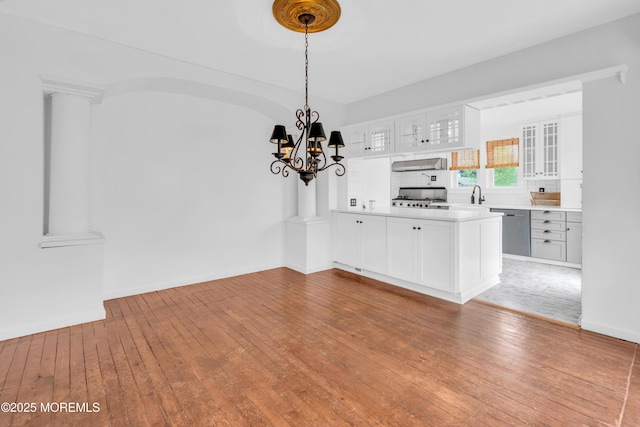 208 Cedar St, Lakehurst, NJ 08733 - unfurnished dining area featuring wood-type flooring, a sink, a chandelier, and baseboards