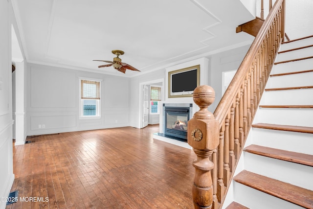 208 Cedar St, Lakehurst, NJ 08733 - unfurnished living room with a glass covered fireplace, ceiling fan, stairs, hardwood / wood-style floors, and crown molding