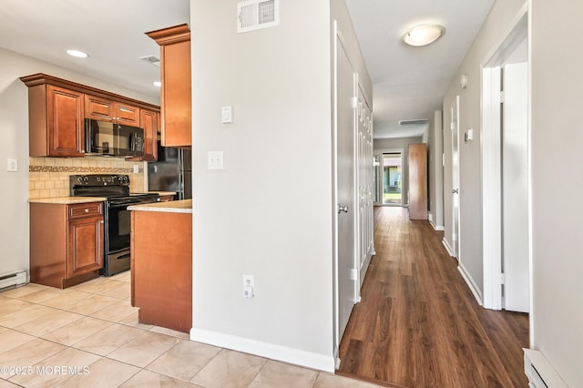 47 Wild Turkey Way Unit E, Manalapan, NJ 07726 - kitchen with black appliances, baseboard heating, tasteful backsplash, brown cabinetry, and recessed lighting