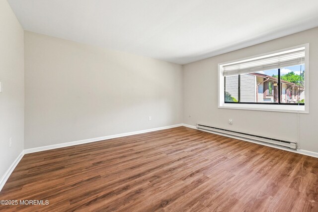 47 Wild Turkey Way Unit E, Manalapan, NJ 07726 - empty room featuring baseboard heating, wood finished floors, and baseboards