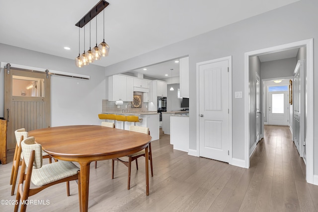 24 Woodview Ln, Cape May Court House, NJ 08210 - dining area featuring a barn door, light wood-style floors, recessed lighting, and baseboards