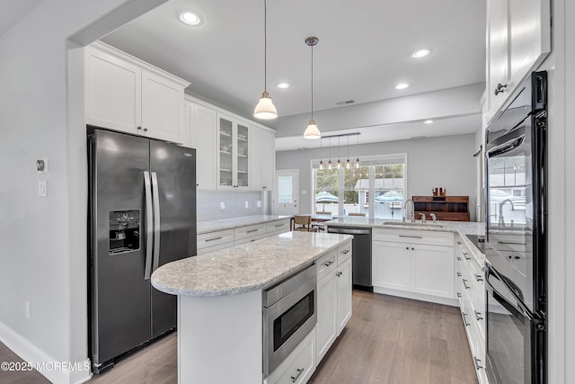 24 Woodview Ln, Cape May Court House, NJ 08210 - kitchen featuring appliances with stainless steel finishes, a sink, a peninsula, light wood-style floors, and glass insert cabinets
