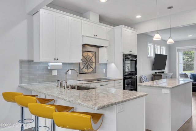 24 Woodview Ln, Cape May Court House, NJ 08210 - kitchen with a sink, black appliances, a kitchen island, backsplash, and white cabinets