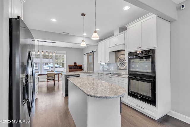 24 Woodview Ln, Cape May Court House, NJ 08210 - kitchen featuring black appliances, a peninsula, a barn door, white cabinetry, and a sink