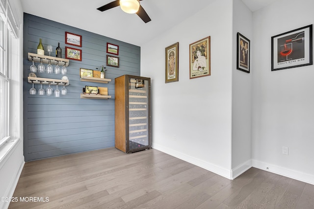 24 Woodview Ln, Cape May Court House, NJ 08210 - unfurnished room with a bar, wine cooler, a ceiling fan, wood finished floors, and wood walls