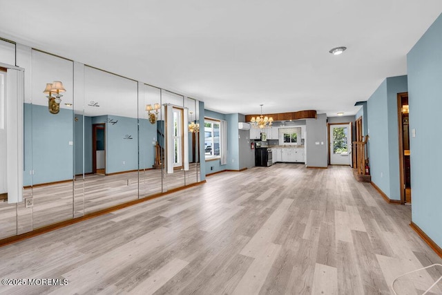 14 Emerald Dr Unit B, Barnegat, NJ 08005 - unfurnished living room featuring a chandelier, light wood-style flooring, and baseboards