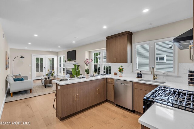 28 Twyford Ln, Manchester, NJ 08759 - kitchen with dishwasher, a sink, open floor plan, a peninsula, and light wood-type flooring