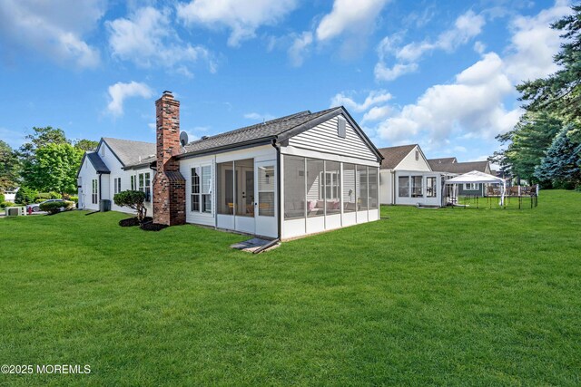 28 Twyford Ln, Manchester, NJ 08759 - back of property with a sunroom, a lawn, and a chimney